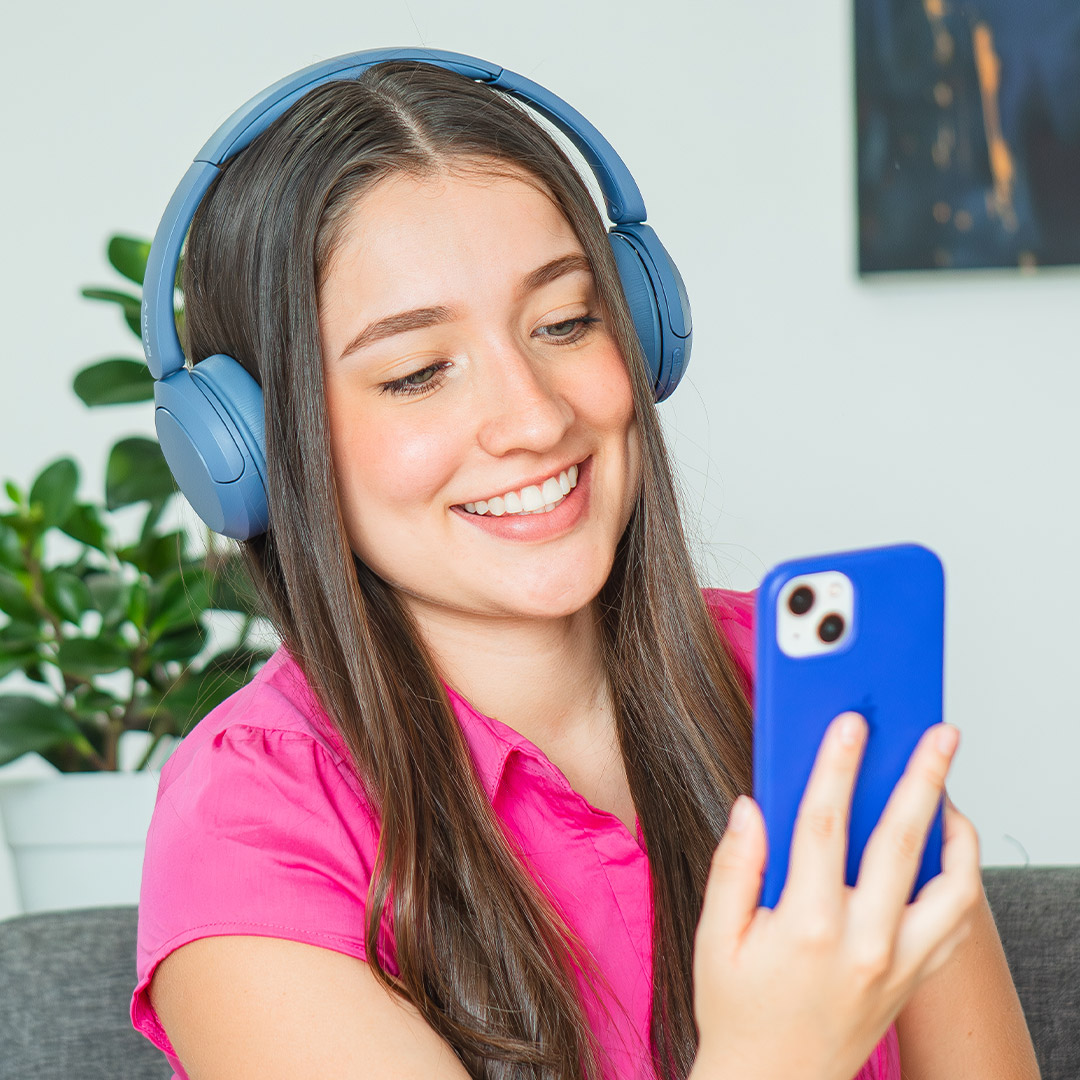 Persona escuchando música con audífonos mientras practica inglés con el ebook Sing & Learn